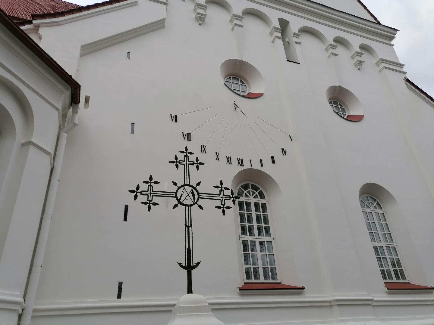 Saulės laikrodis ant katedros sienos.